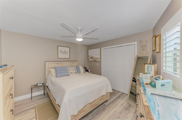 bedroom with a ceiling fan, light wood-type flooring, a closet, and baseboards