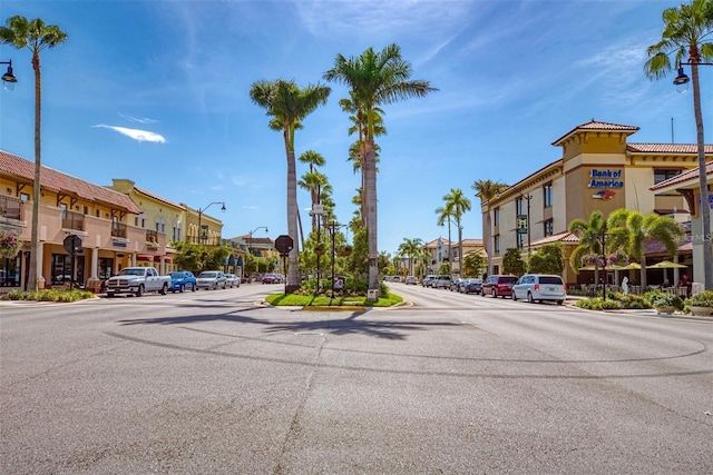 view of street with sidewalks, a residential view, curbs, and street lights