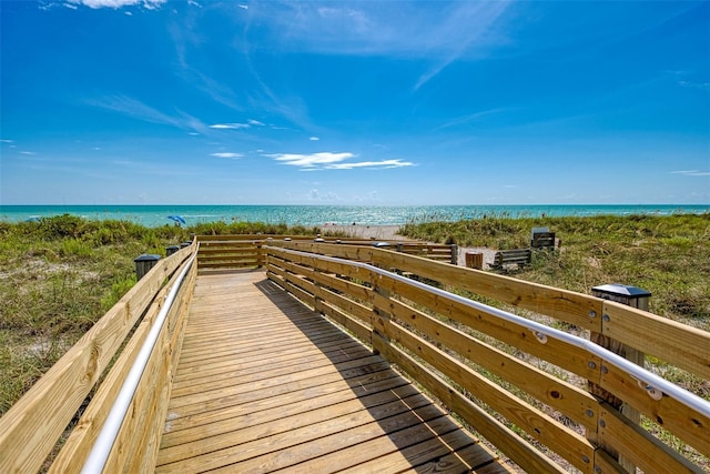 surrounding community with a water view and a beach view