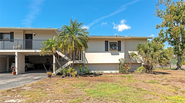 view of side of home featuring a carport, driveway, and a lawn