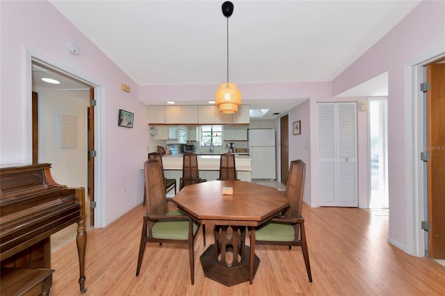 dining area with baseboards and light wood finished floors