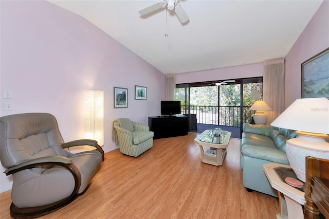 living room with a ceiling fan, lofted ceiling, and wood finished floors