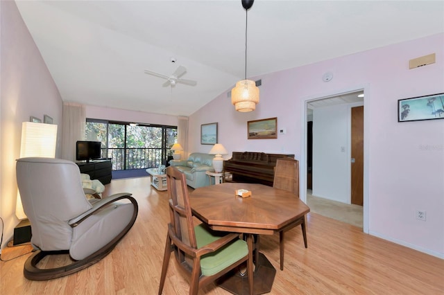 dining room with light wood-type flooring, vaulted ceiling, baseboards, and ceiling fan