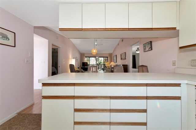 kitchen with light countertops, open floor plan, white cabinets, and a peninsula