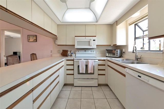 kitchen with light countertops, white appliances, and a sink