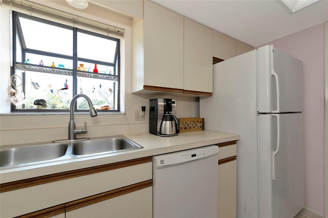 kitchen featuring light countertops, white appliances, a sink, and a healthy amount of sunlight