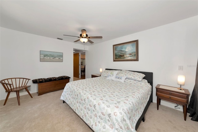 bedroom with visible vents, a ceiling fan, and light colored carpet