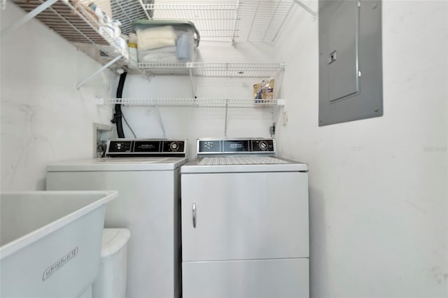 washroom featuring laundry area, electric panel, a sink, and separate washer and dryer