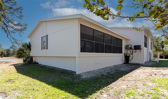 view of home's exterior with crawl space, a sunroom, and a lawn