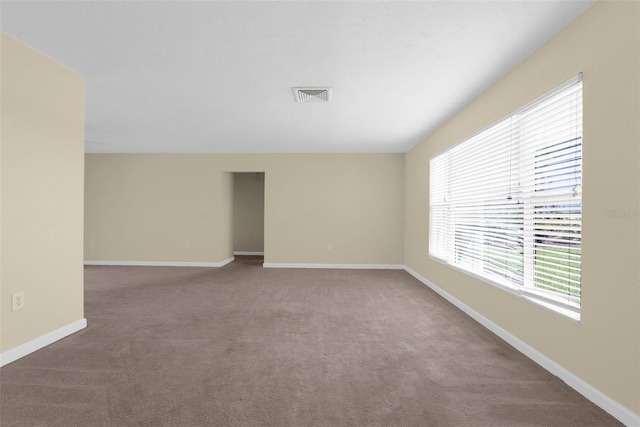carpeted spare room with visible vents and baseboards