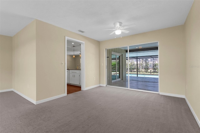 spare room featuring baseboards, ceiling fan, and carpet floors