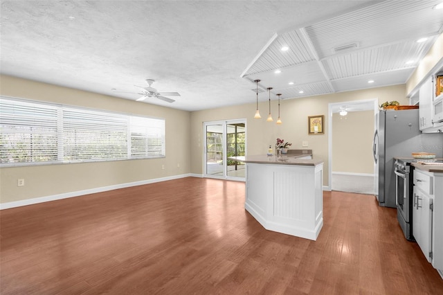 kitchen featuring recessed lighting, baseboards, ceiling fan, wood finished floors, and stainless steel appliances
