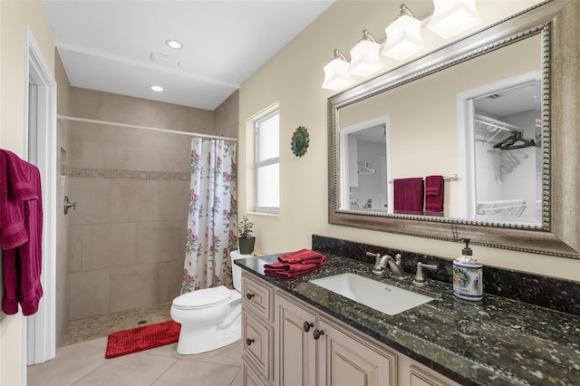 full bathroom with vanity, tile patterned flooring, toilet, and a tile shower