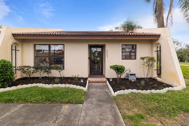 view of front of home with a tiled roof and stucco siding