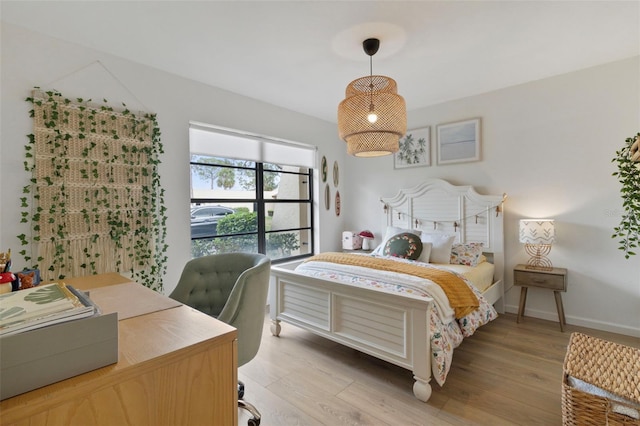 bedroom featuring light wood finished floors and baseboards