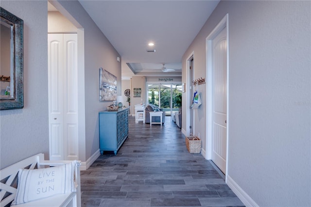 corridor featuring baseboards and wood finished floors