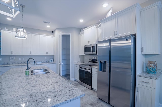 kitchen featuring visible vents, pendant lighting, a sink, appliances with stainless steel finishes, and white cabinets