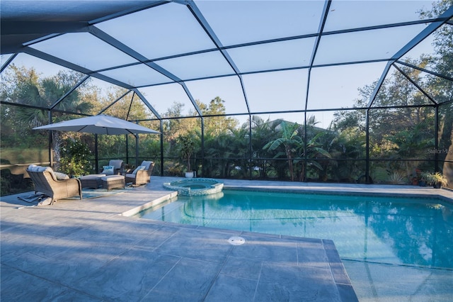 view of pool featuring glass enclosure, a pool with connected hot tub, and a patio