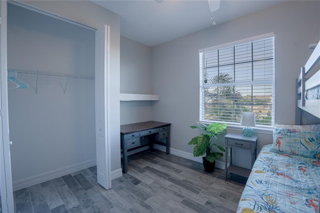 bedroom featuring a closet, a ceiling fan, baseboards, and wood finished floors