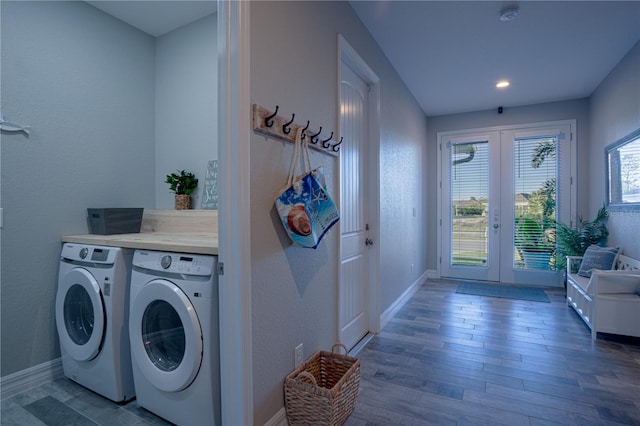 clothes washing area with wood finished floors, baseboards, laundry area, french doors, and washer and dryer