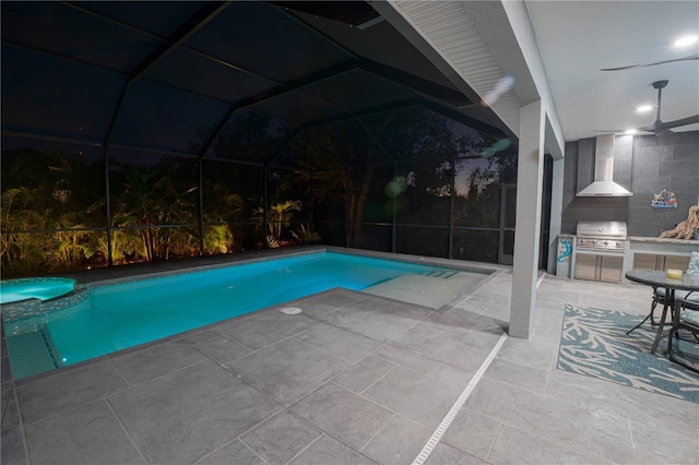 view of pool with area for grilling, a pool with connected hot tub, exterior kitchen, a lanai, and a patio area