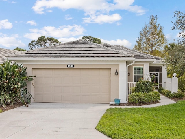 ranch-style home with an attached garage, stucco siding, concrete driveway, and a tiled roof