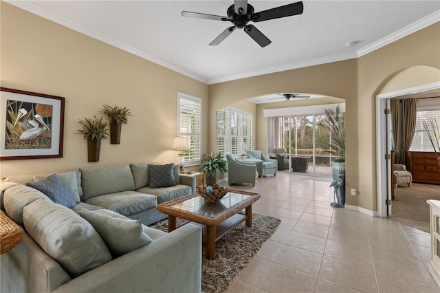 living area with a textured ceiling, ornamental molding, light tile patterned flooring, and baseboards