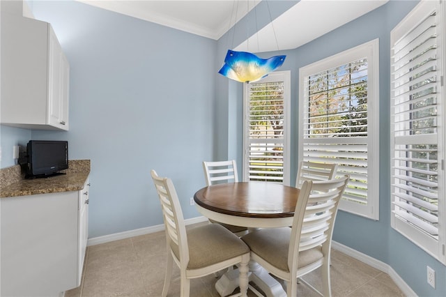 dining area featuring light tile patterned floors, baseboards, and crown molding