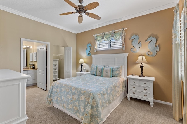 bedroom with baseboards, light colored carpet, ceiling fan, ensuite bathroom, and crown molding