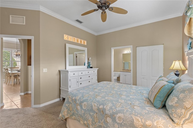 carpeted bedroom with visible vents, crown molding, and ensuite bathroom