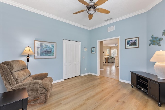 sitting room featuring ornamental molding, visible vents, light wood-style floors, and baseboards