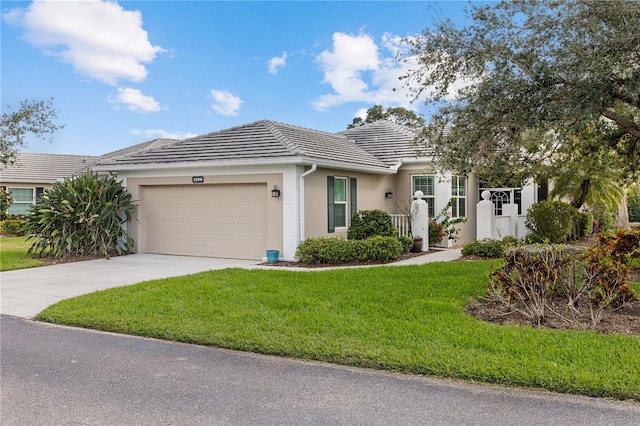 ranch-style house with stucco siding, concrete driveway, an attached garage, a front yard, and a tiled roof