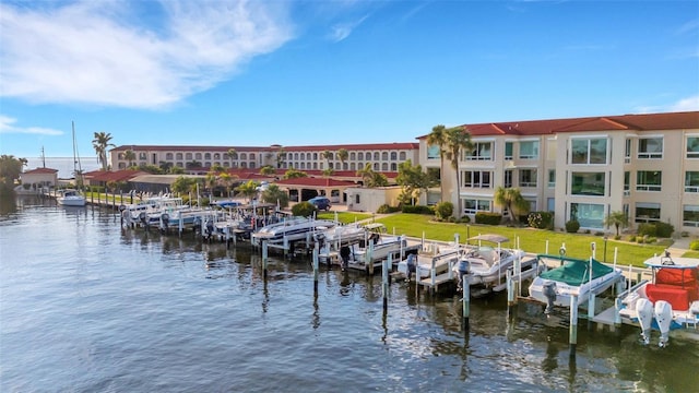 view of dock with a water view, a lawn, and boat lift