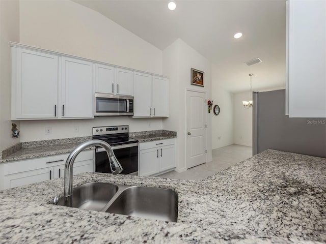 kitchen featuring visible vents, light stone counters, appliances with stainless steel finishes, white cabinetry, and a sink