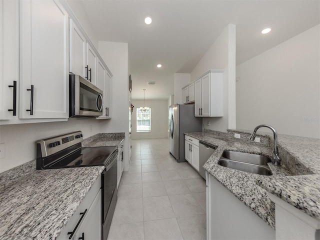 kitchen with a sink, recessed lighting, light stone countertops, and stainless steel appliances