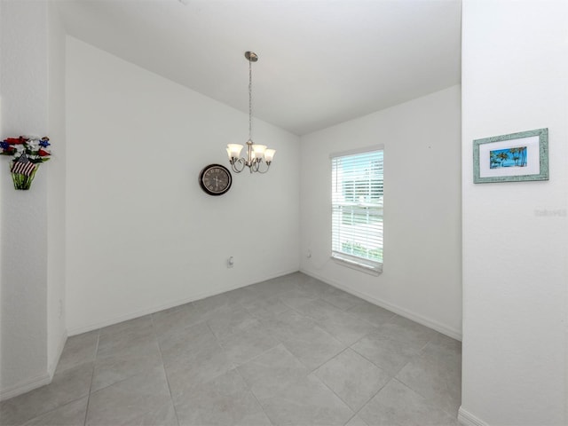 spare room with baseboards, a notable chandelier, light tile patterned flooring, and vaulted ceiling