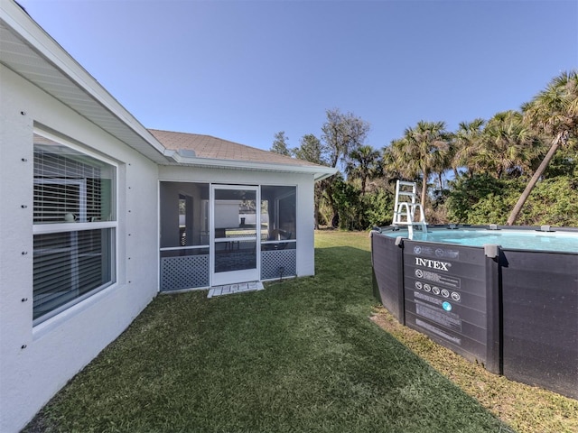 view of yard with an outdoor pool and a sunroom