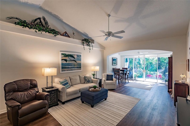 living area featuring ceiling fan, arched walkways, vaulted ceiling, and wood finished floors