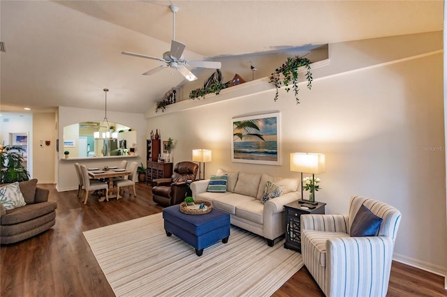 living room featuring lofted ceiling, baseboards, wood finished floors, and ceiling fan with notable chandelier