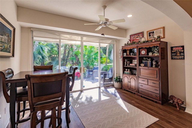 dining room with arched walkways, dark wood-type flooring, a ceiling fan, and recessed lighting