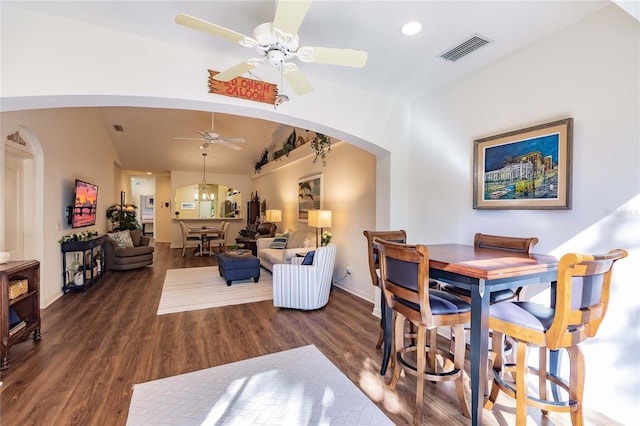 interior space with arched walkways, lofted ceiling, ceiling fan with notable chandelier, wood finished floors, and visible vents