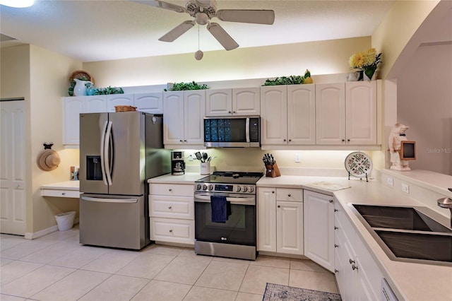 kitchen featuring light tile patterned flooring, stainless steel appliances, a sink, white cabinets, and light countertops