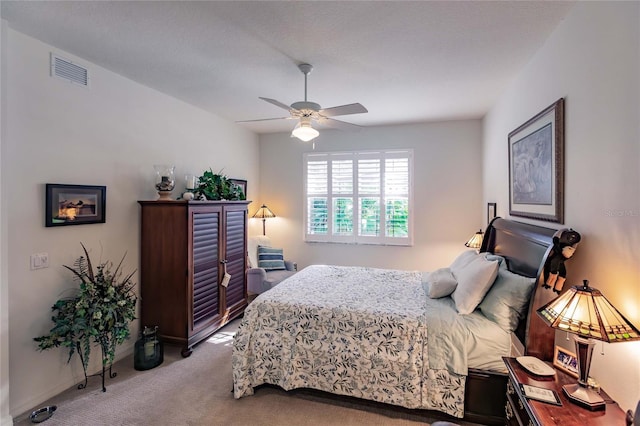 carpeted bedroom with visible vents, ceiling fan, and baseboards