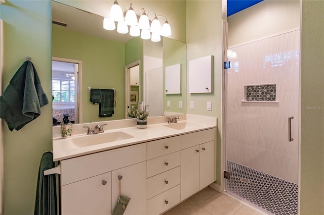 ensuite bathroom featuring double vanity, tile patterned flooring, a sink, and tiled shower