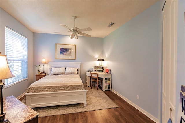 bedroom featuring ceiling fan, dark wood-style flooring, visible vents, and baseboards