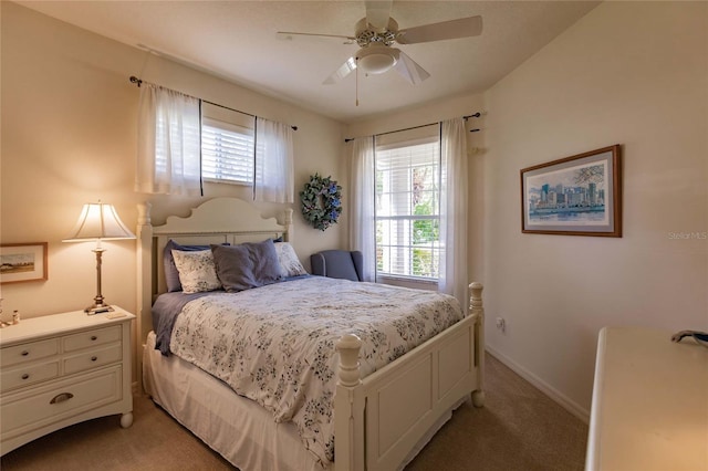 bedroom featuring a ceiling fan, light carpet, and baseboards