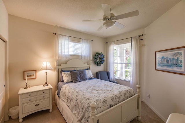 bedroom with baseboards, ceiling fan, and light colored carpet