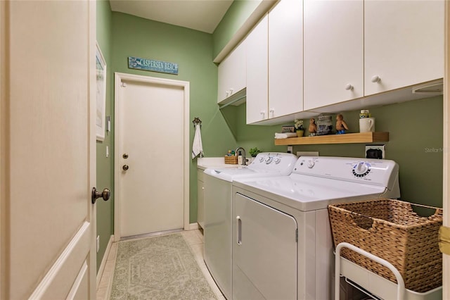 laundry room featuring light tile patterned flooring, washing machine and dryer, and cabinet space