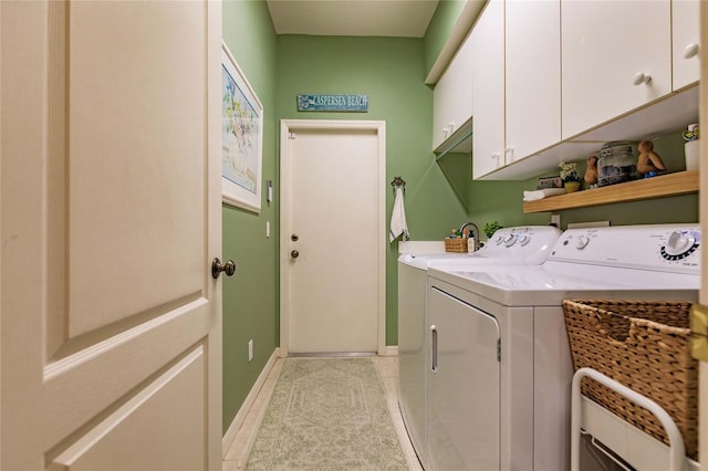 clothes washing area featuring washing machine and dryer, cabinet space, baseboards, and light tile patterned floors