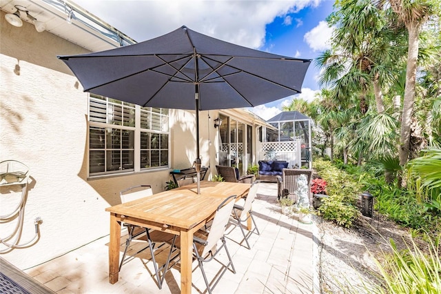 view of patio featuring outdoor dining area and a lanai